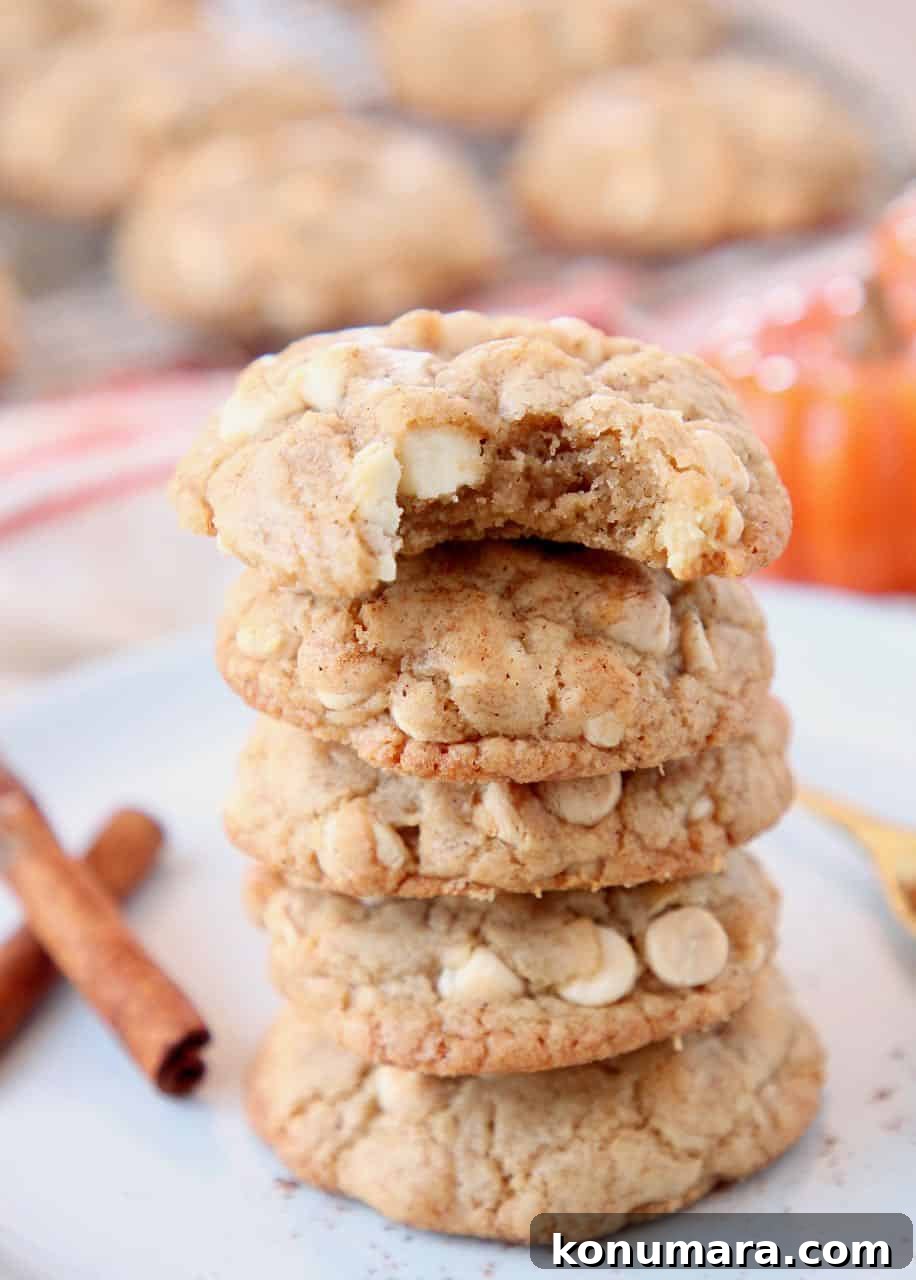 Stacked up pumpkin spice cookies on plate with cinnamon sticks