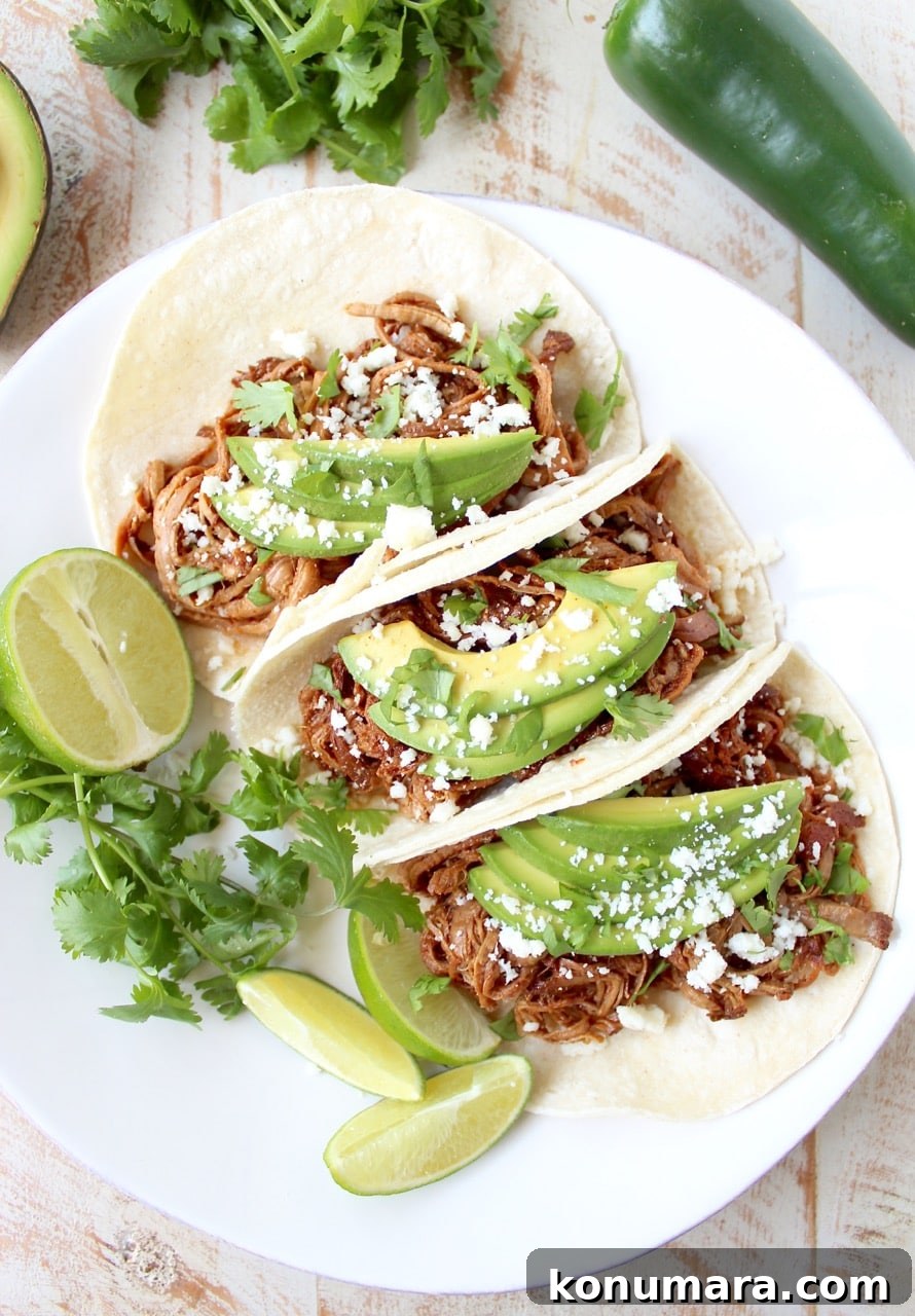 Slow Cooker Chipotle Honey Pulled Pork Tacos Recipe 5 Finished pulled pork tacos with avocado and cotija cheese.