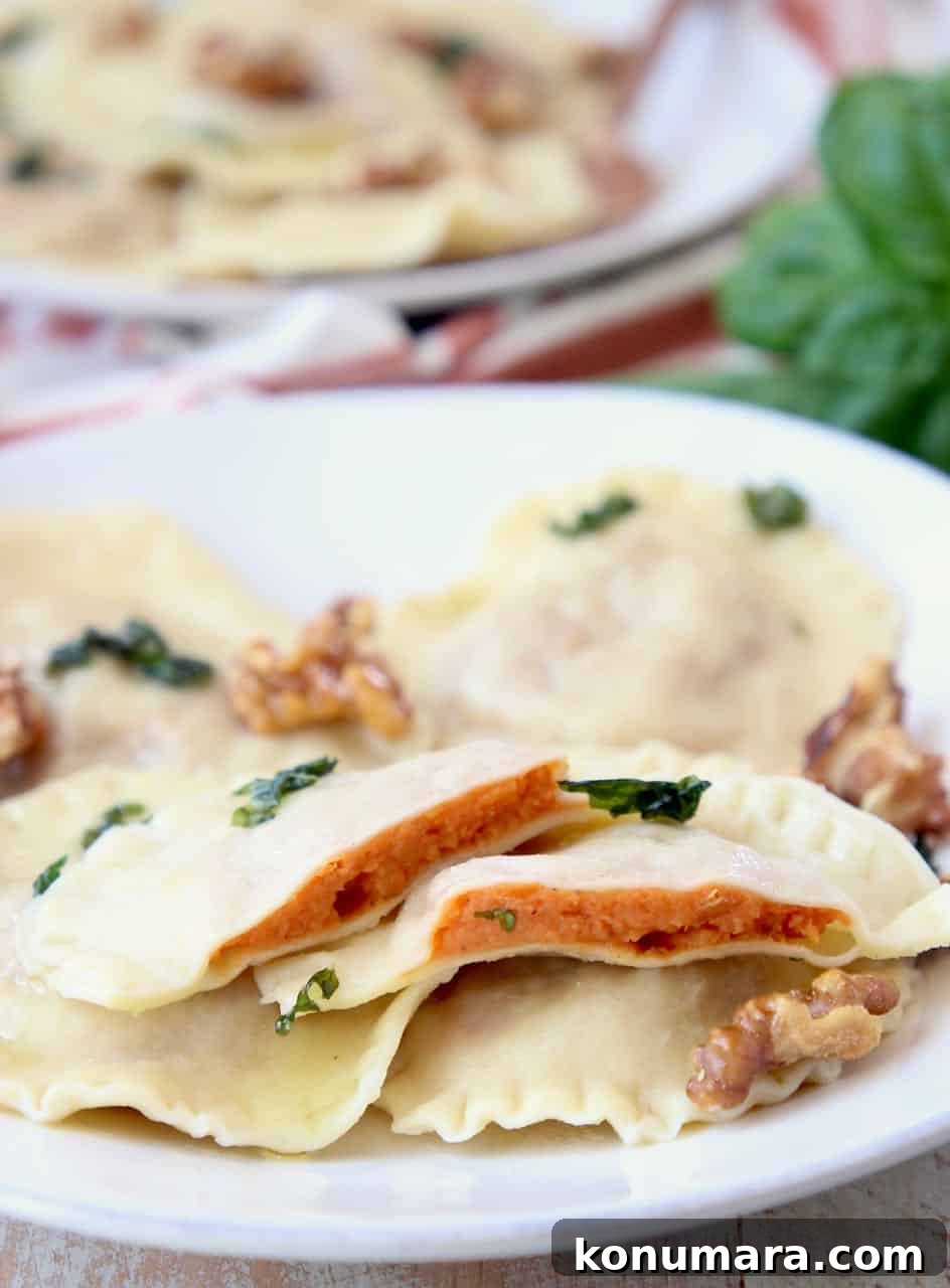Sweet potato ravioli sliced in half on plate with whole raviolis and walnuts
