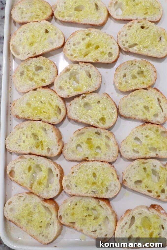 slices of baguette brushed with oil on a baking sheet