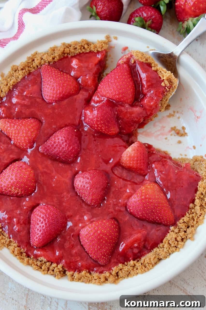 Fresh Strawberry Pie Recipe with Graham Cracker Crust 5 Slice being lifted out of strawberry pie