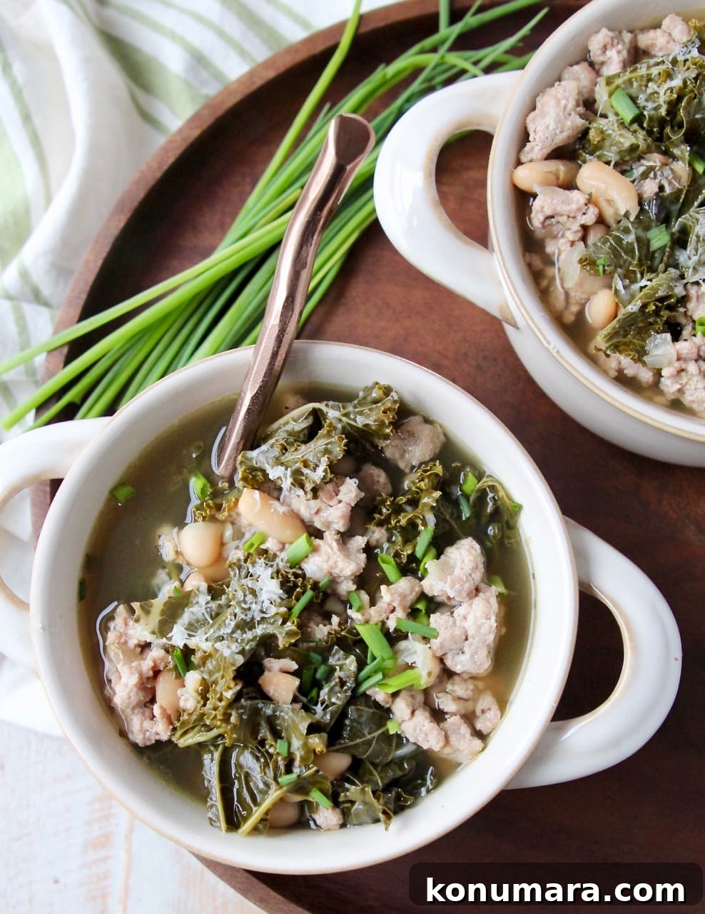 Hearty Slow Cooker Turkey and Kale Soup 4 Kale Turkey Soup in white soup crocks on wood tray with fresh chives