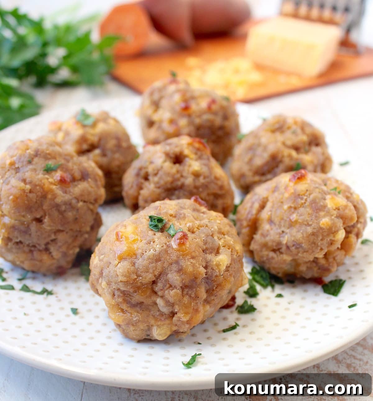 Gluten-Free Sweet Potato Sausage Balls Recipe 7 Sweet potato sausage balls on a white plate.