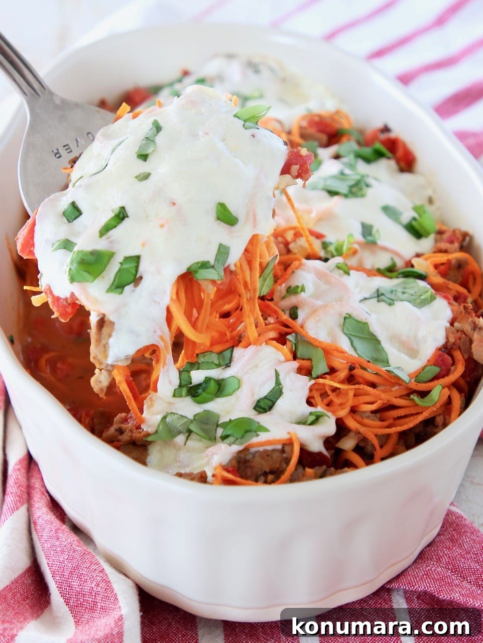 Baked Italian Turkey and Sweet Potato Casserole 5 Large fork scooping out of a sweet potato casserole covered in mozzarella cheese