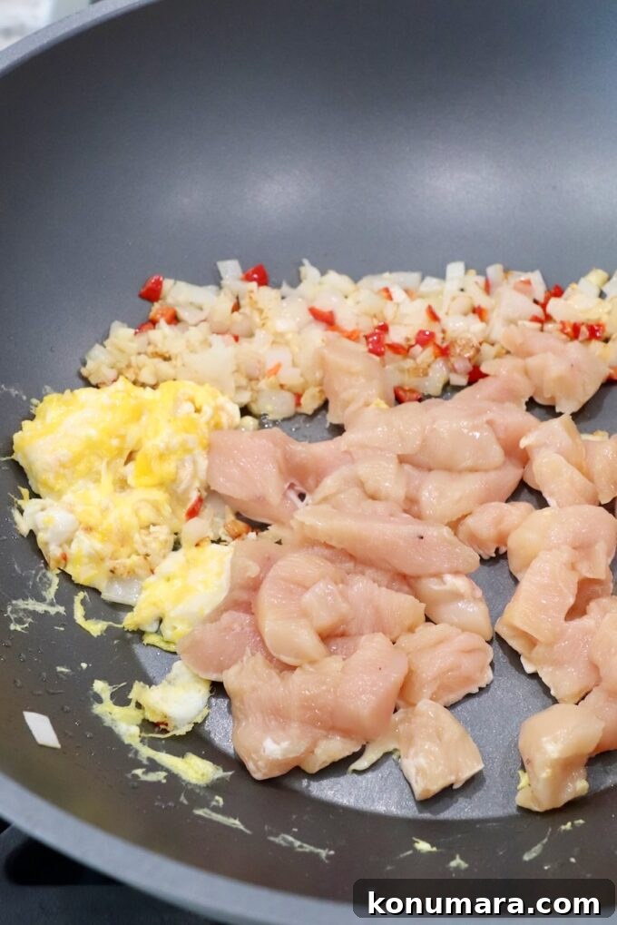 Authentic Thai Drunken Noodles (Pad Kee Mao) Recipe 7 diced raw chicken in large wok with scrambled eggs and diced vegetables