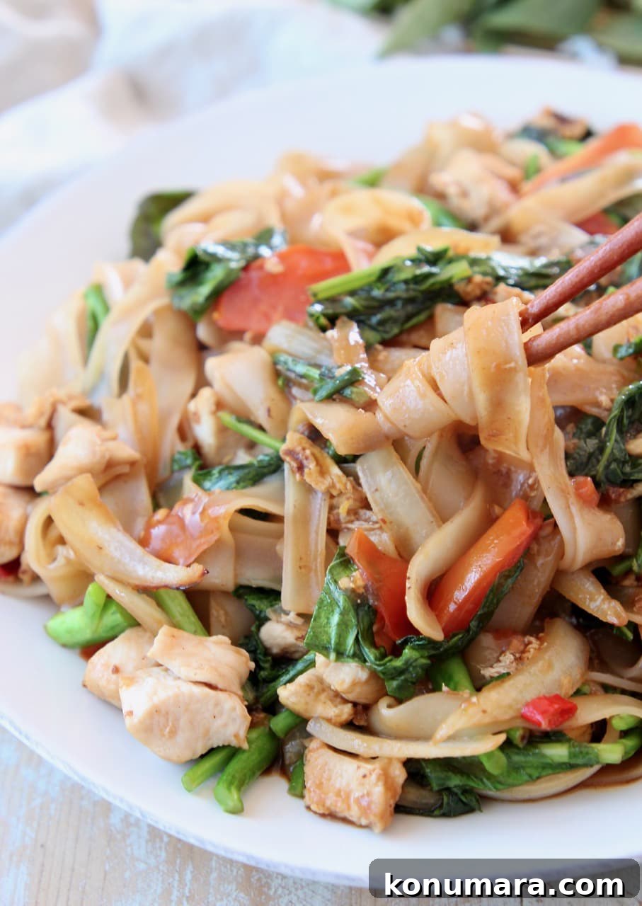 Authentic Thai Drunken Noodles (Pad Kee Mao) Recipe 10 Drunken noodles, twirled around chopsticks on white plate