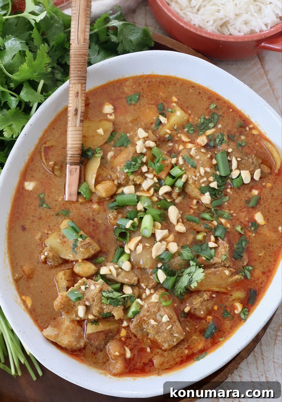 Slow Cooker Massaman Curry Chicken 2 chicken and vegetables in curry sauce in bowl with serving spoon