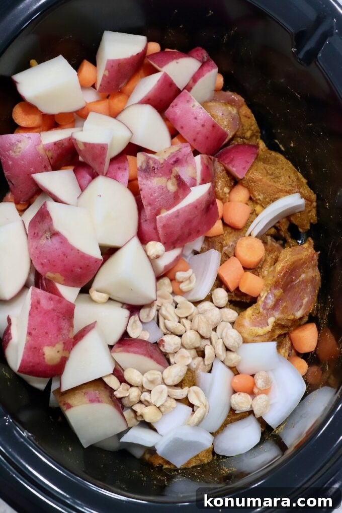 Slow Cooker Massaman Curry Chicken 4 seasoned chicken in slow cooker with vegetables and peanuts