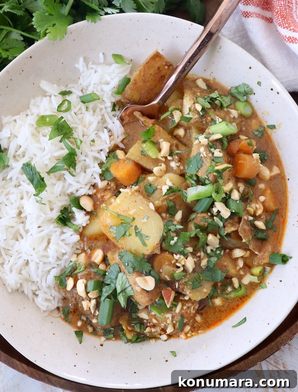 Slow Cooker Massaman Curry Chicken 6 massman curry chicken and vegetables in bowl with white rice and fork
