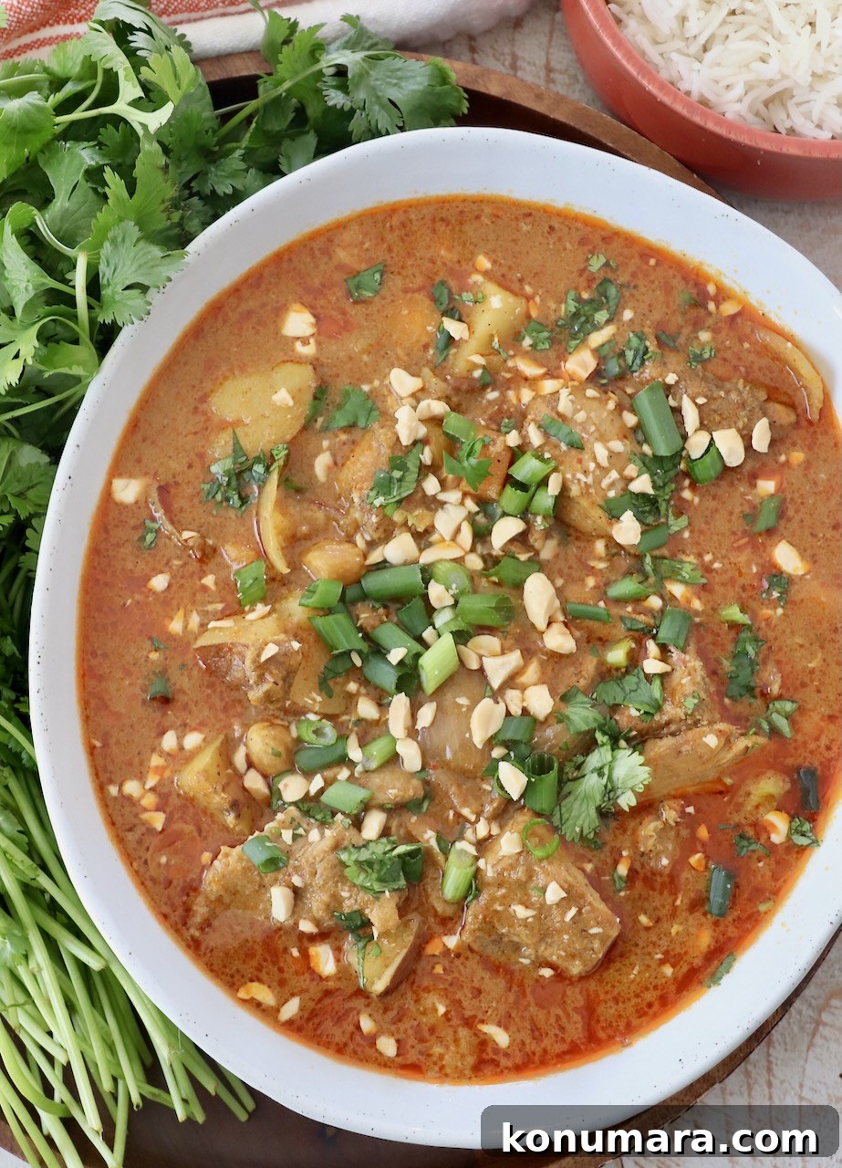 Slow Cooker Massaman Curry Chicken 7 massaman curry chicken in bowl topped with fresh herbs and chopped peanuts