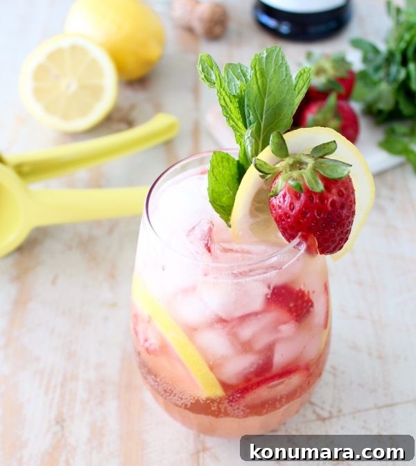 prosecco sangria in glass with strawberry, lemon and mint garnish
