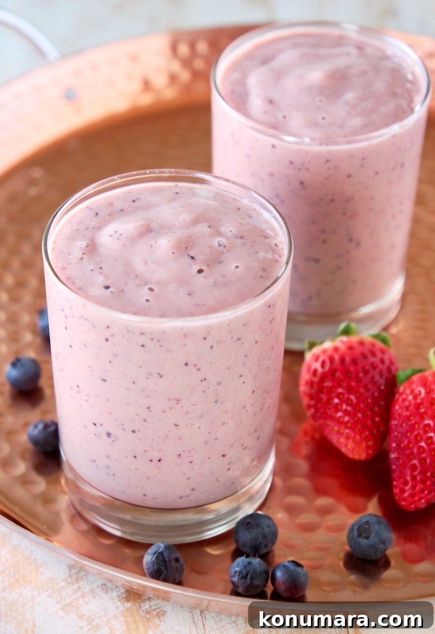 Fruit Smoothie for Heart Health 2 Heart healthy fruit smoothie in two glasses on copper tray with fresh strawberries and blueberries