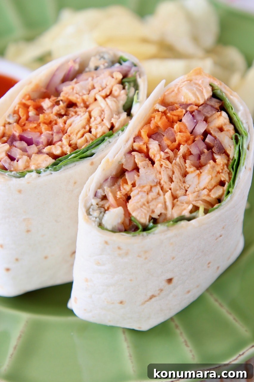 Buffalo chicken wrap sliced in half on green plate