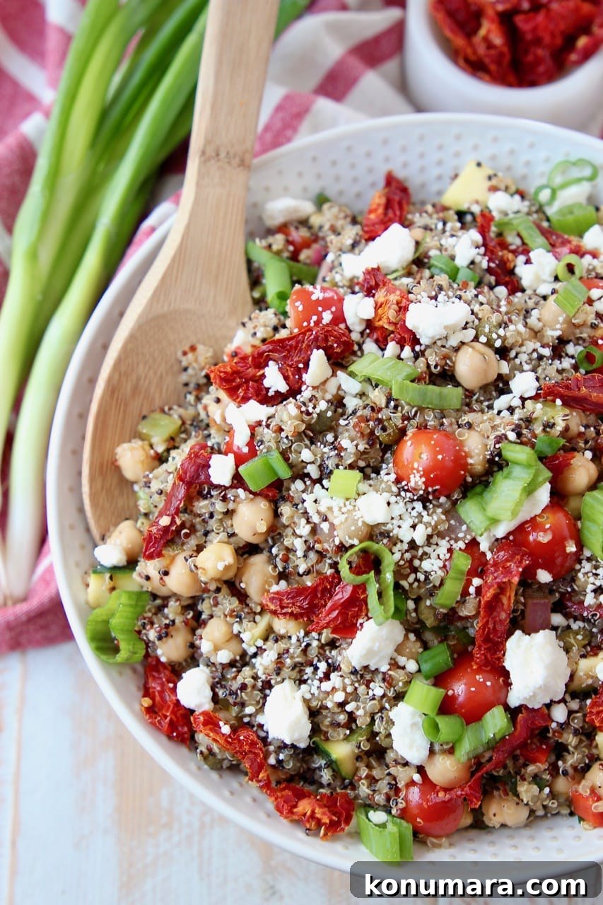 Overhead shot of quinoa salad with sun dried tomatoes, green onions and feta cheese crumbles