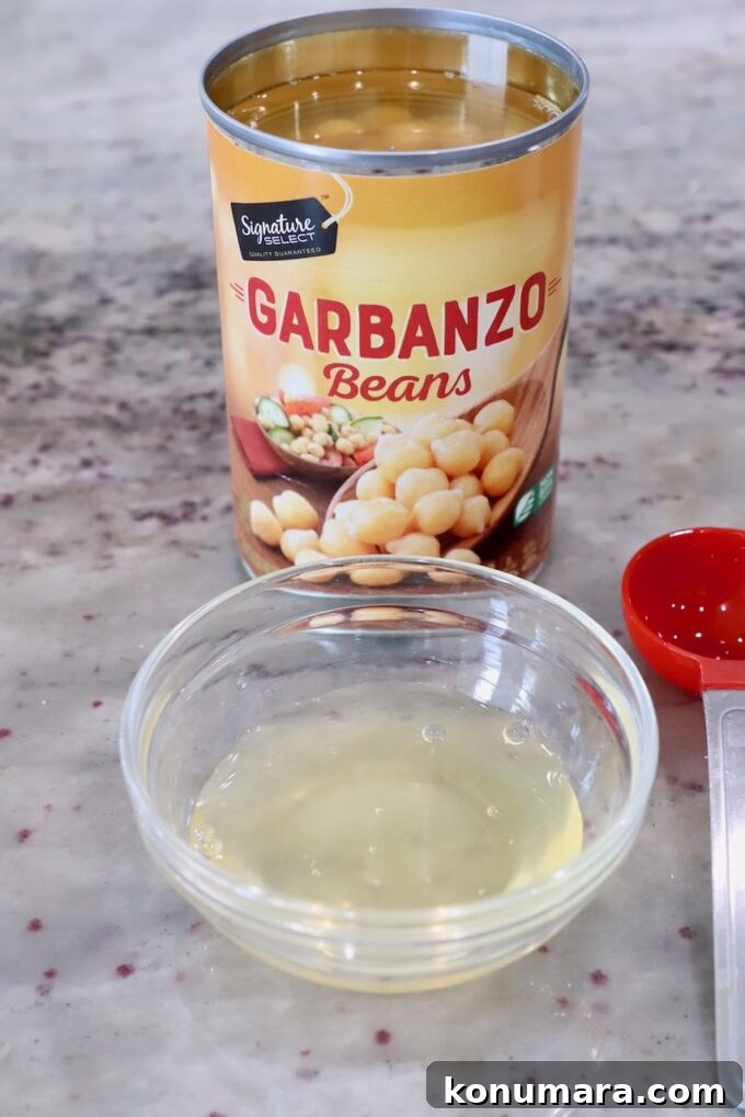 Creamy Roasted Beet Hummus with Lemon and Garlic 9 aquafaba removed from can of garbanzo beans in small glass bowl