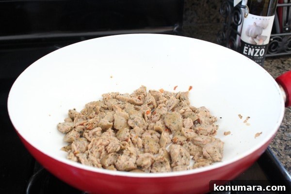 Mediterranean Sausage-Stuffed Shells Recipe 6 Sausage cooking in a red and white skillet.