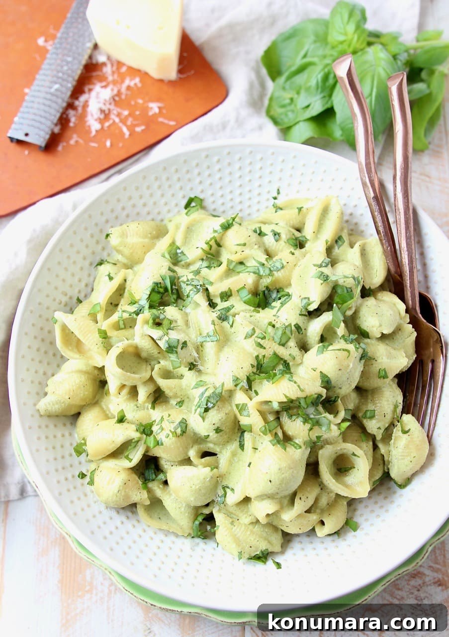 Cheesy Basil Pesto Pasta Recipe with Parmesan 2 Cheesy pesto pasta shells in large white bowl with copper forks in the bowl
