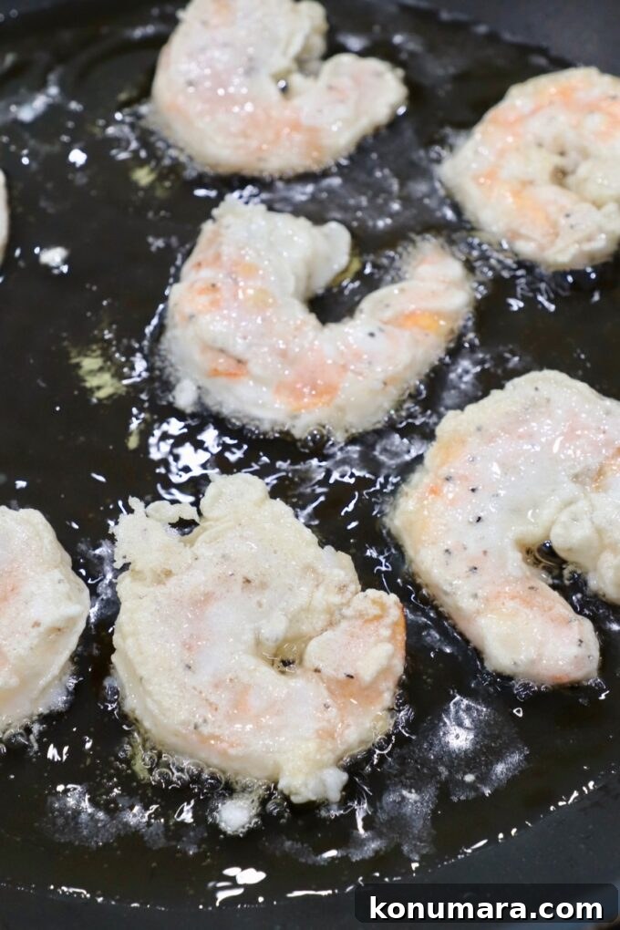 Crispy Honey Walnut Shrimp with Candied Walnuts 7 battered shrimp cooking in oil in skillet