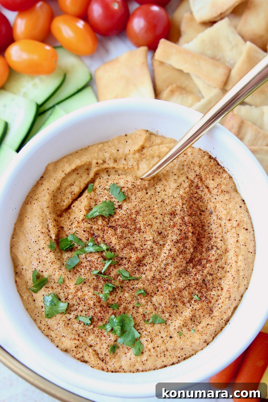 Sriracha hummus in bowl with gold spoon