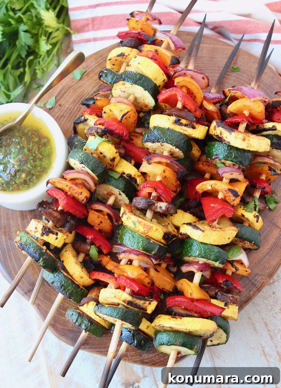 Grilled Vegetable Skewers Recipe with Garlic Herb Marinade 8 skewers of grilled vegetables on wood serving tray with chimichurri sauce on the side