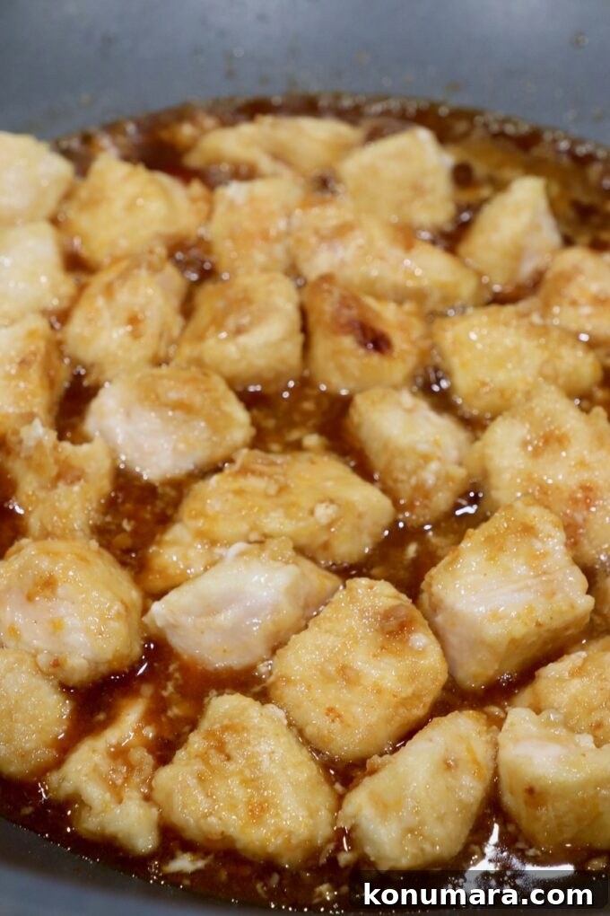 cooked pieces of chicken in orange sauce in skillet