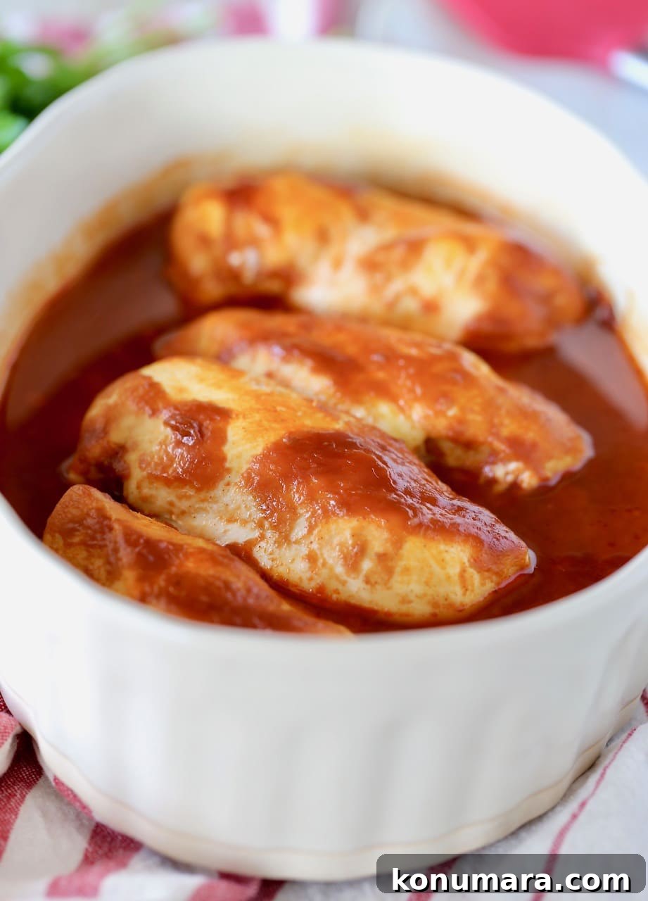 Oven Baked Buffalo BBQ Chicken 5 Baked BBQ Buffalo Chicken in oval casserole dish on top of red and white striped towel