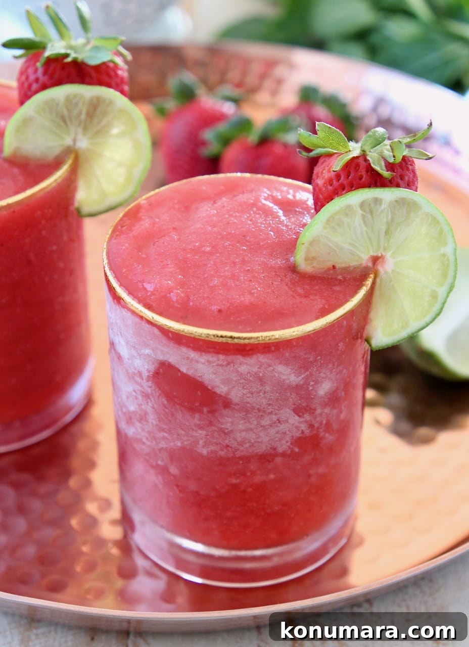 Strawberry Daiquiri Recipe with Basil-Infused Simple Syrup 2 Frozen strawberry daiquiri in glass with lime wedge and strawberry on the side