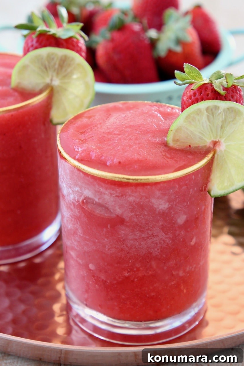 Strawberry Daiquiri Recipe with Basil-Infused Simple Syrup 4 Blended strawberry daiquiri in glass with lime wedge on the side
