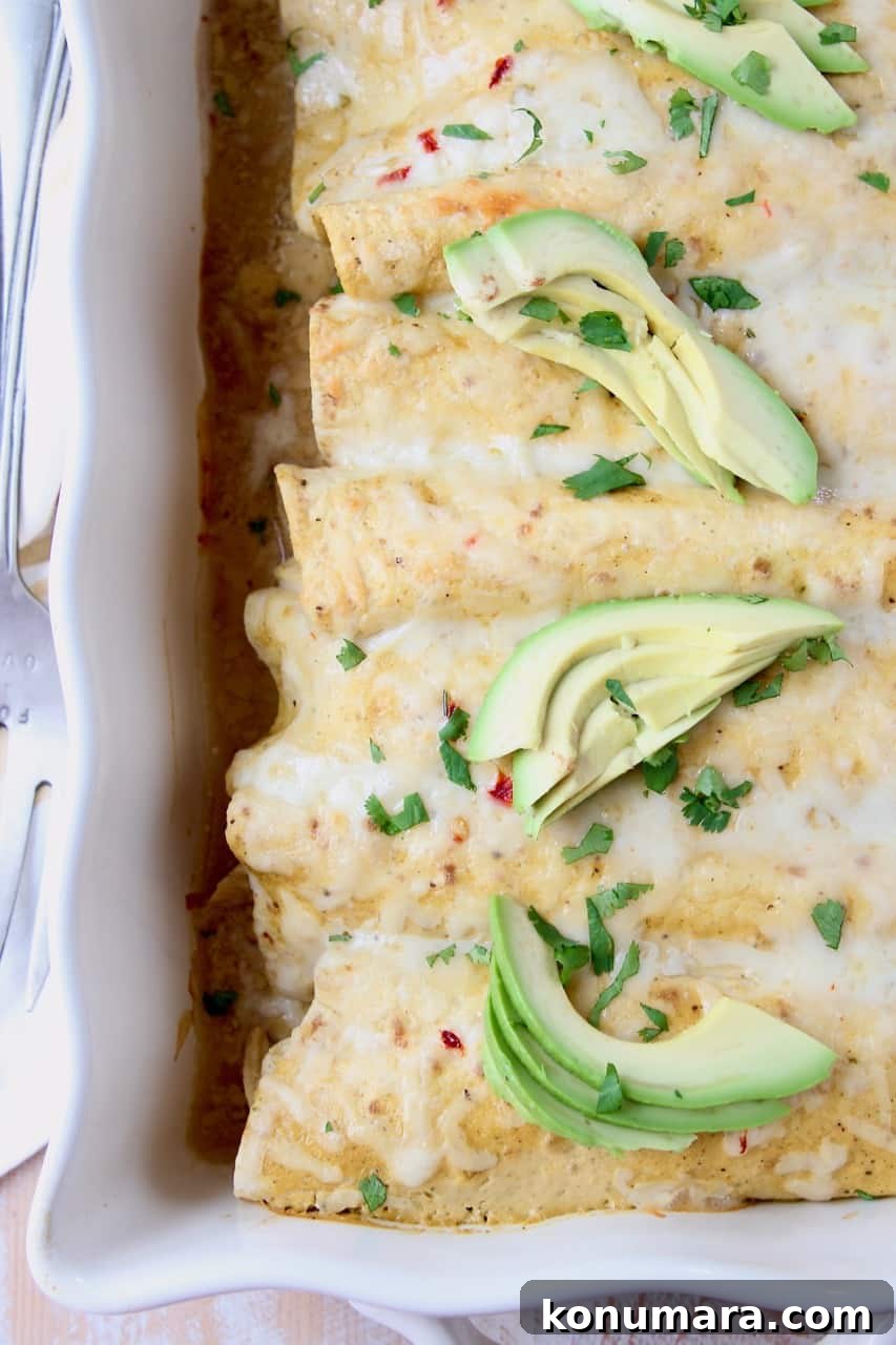 Enchiladas in casserole dish, topped with sliced avocado