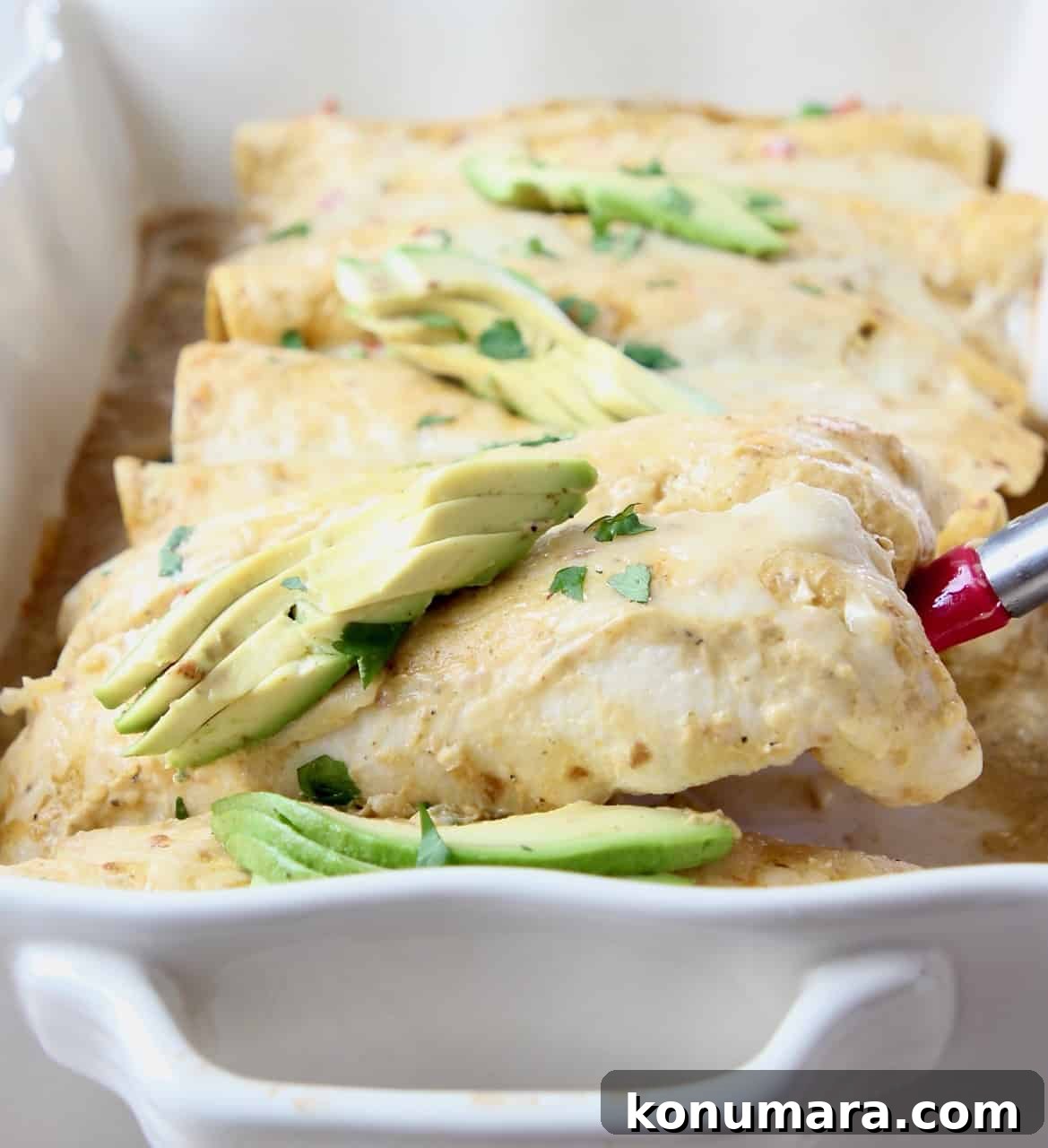 Enchilada lifted out of baking dish with spatula