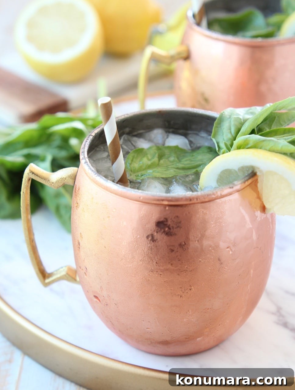 Peach and Basil Moscow Mule Cocktail Recipe 3 Copper mug filled with vodka, ice, ginger beer, fresh lemon and basil