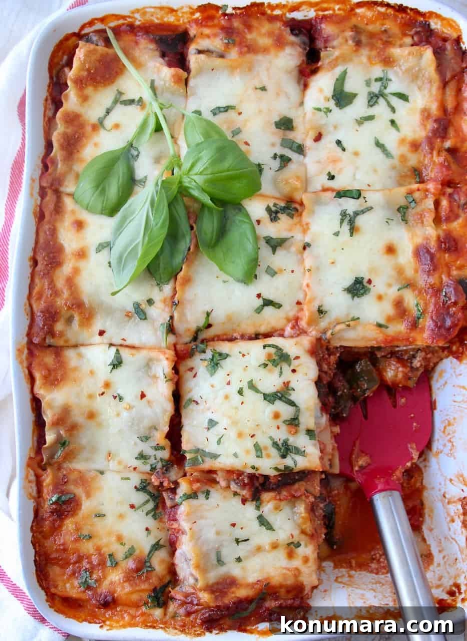 Classic Vegetarian Lasagna Recipe with Spinach and Ricotta 5 overhead image of lasagna in casserole dish cut into squares with red spatula