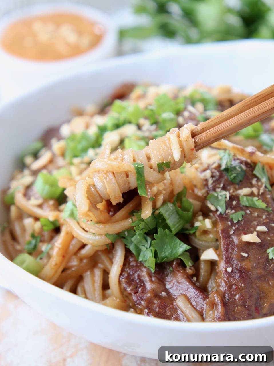 Authentic Thai Beef Noodle Bowl Recipe 4 Rice noodles swirled around chopsticks in a Thai beef noodle bowl