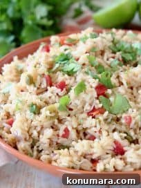 Mexican rice with tomatoes, topped with fresh cilantro in orange bowl