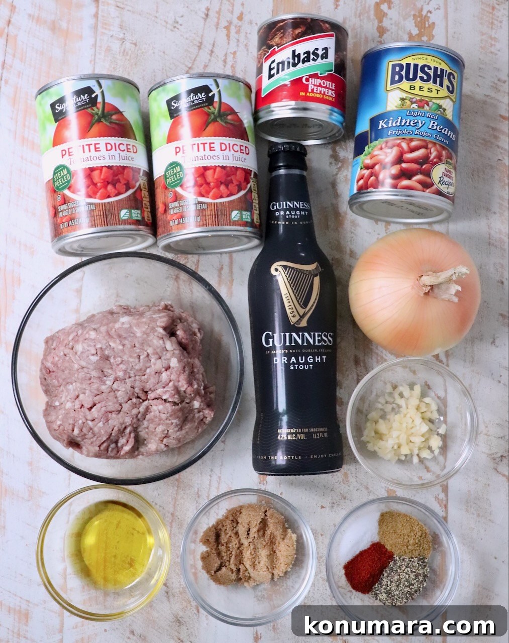 ingredients for chipotle stout chili on a white wood board