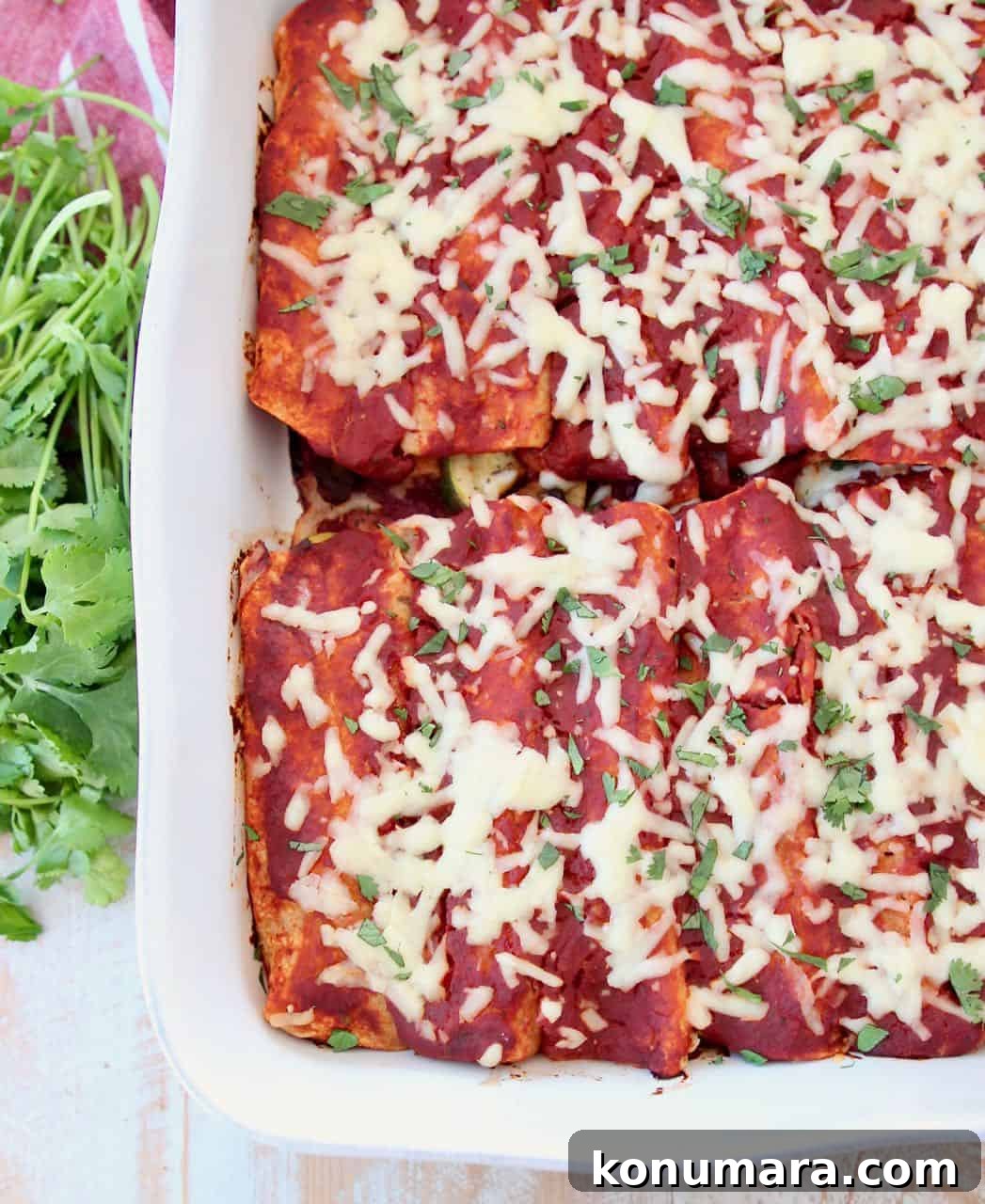 Enchiladas with red sauce in white casserole baking dish