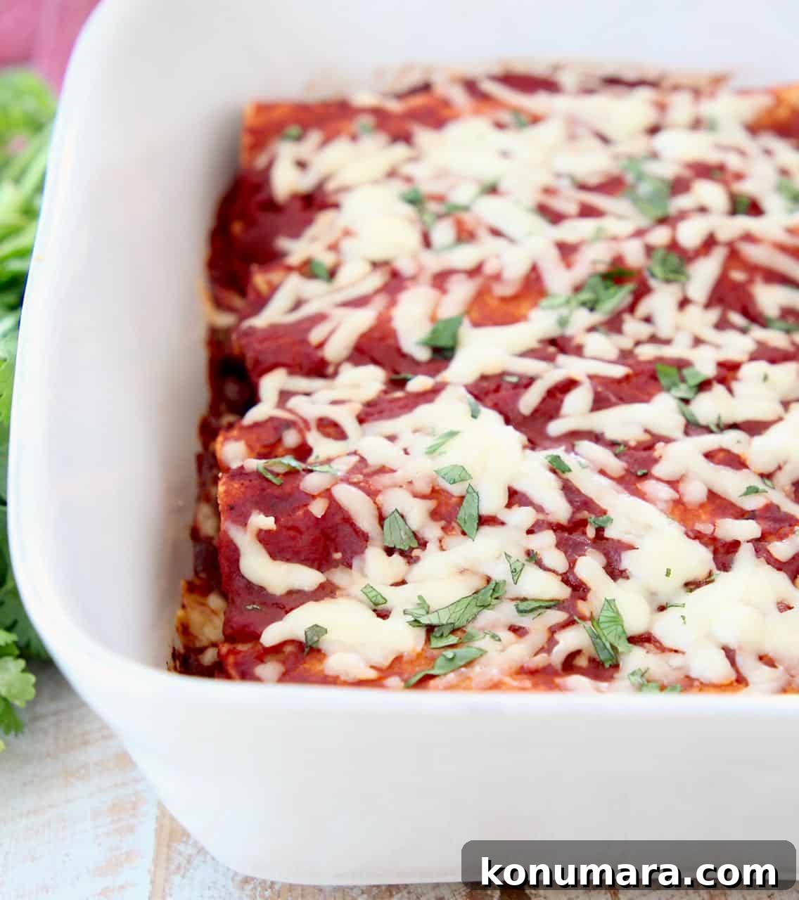 Veggie enchiladas with red sauce and cheese in casserole dish