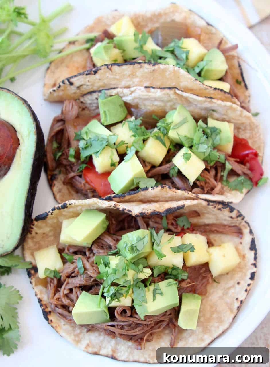 Three shredded tri tip tacos on plate with avocado
