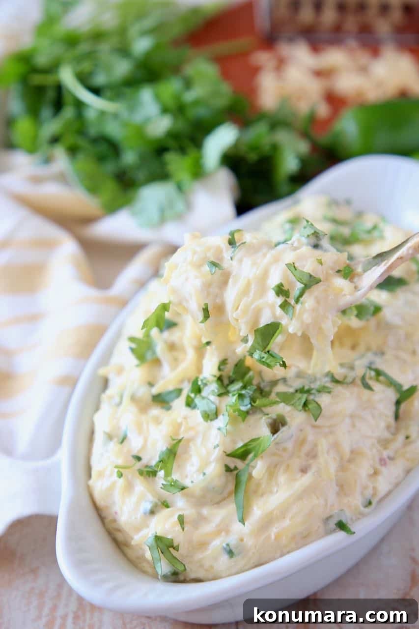 Fork coming out of bowl of roasted spaghetti squash with cheese sauce