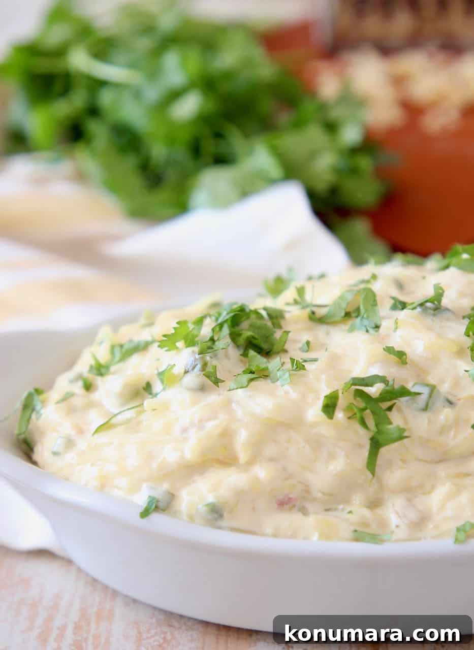 Spaghetti squash tossed with jalapeno cheese sauce in white baking dish