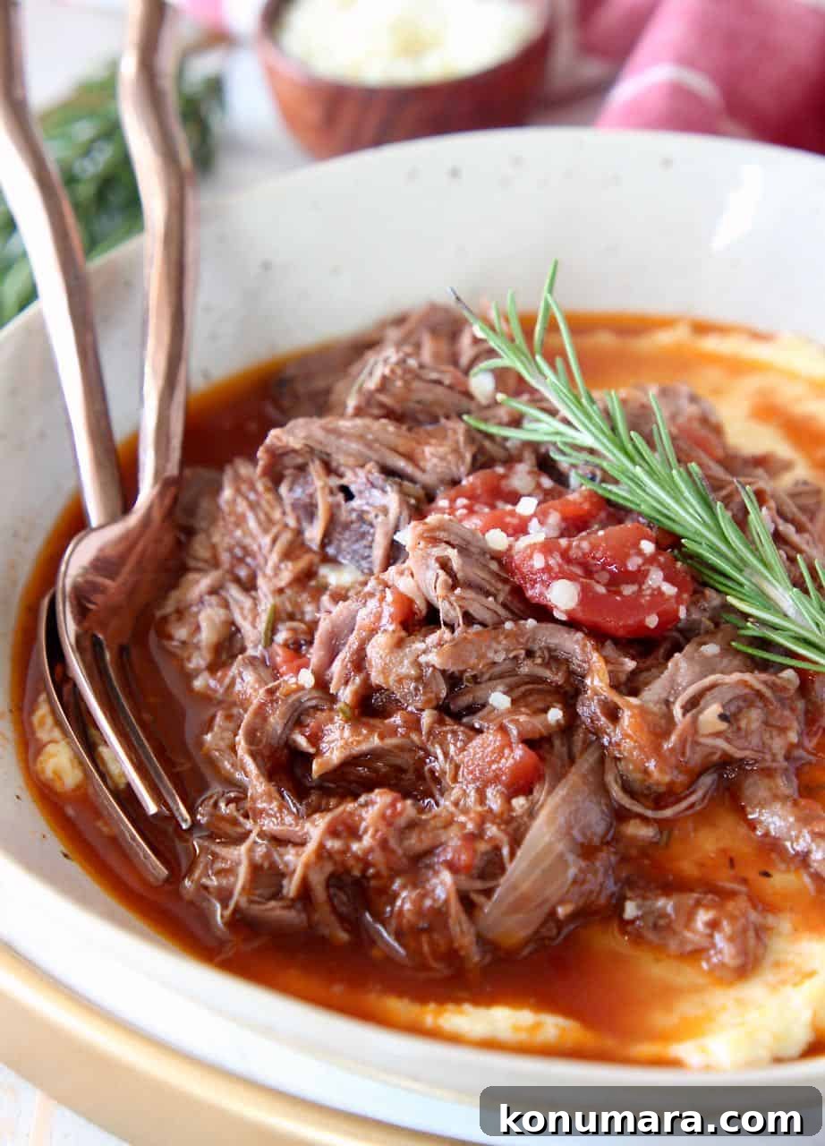 Slow Cooker Beef Ragu Recipe for Pasta 4 Shredded beef ragu in bowl served over polenta with fresh rosemary