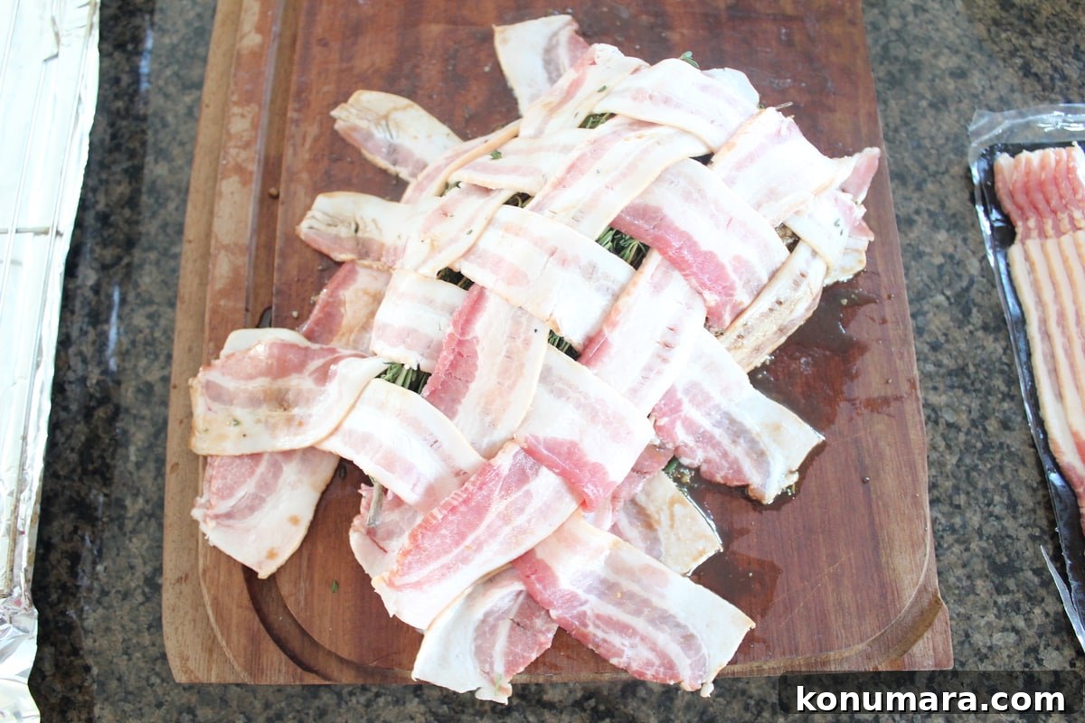 Crispy Bacon-Wrapped Turkey Breast Recipe 5 Bacon weave on top of turkey breast on wood cutting board