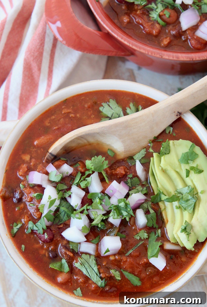 Hearty Slow Cooker Vegan Chili Recipe 2 vegan chili in bowl with spoon and sliced avocado