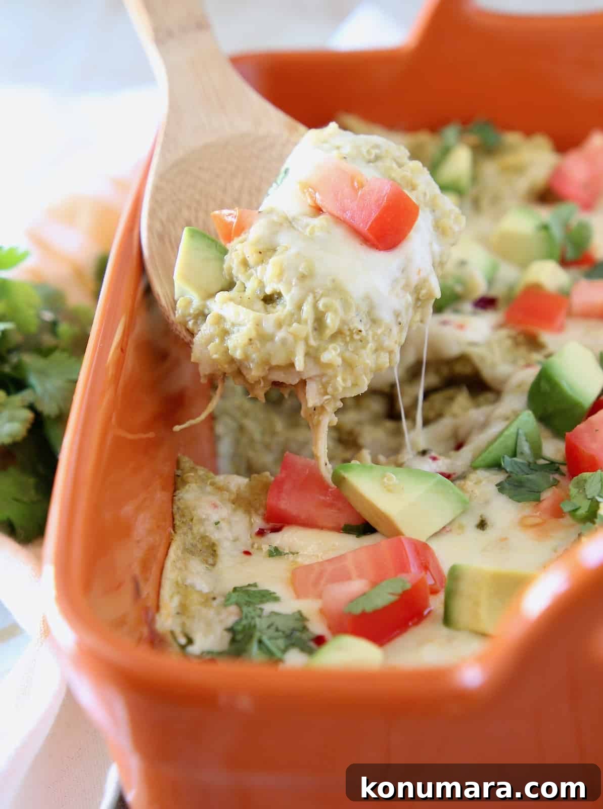 Baked Chicken Enchilada Casserole Recipe 4 Wooden spoon of quinoa chicken enchilada casserole, topped with cheese and diced tomatoes