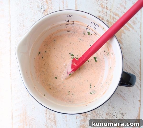 Buffalo Potato Salad with Blue Cheese and Celery 5 creamy buffalo sauce dressing in a bowl with a red spatula