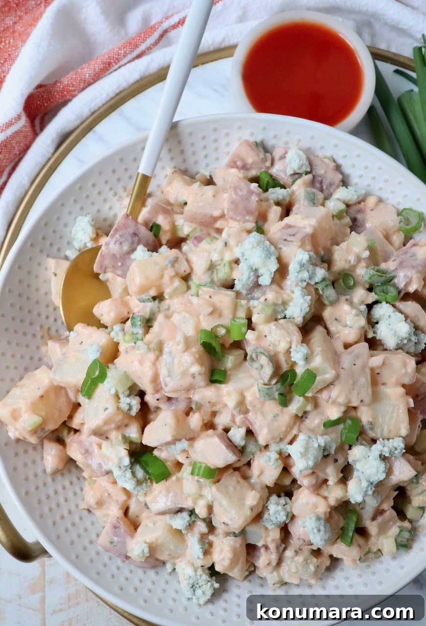 Buffalo Potato Salad with Blue Cheese and Celery 7 potato salad in bowl with spoon and small bowl of buffalo sauce on the side