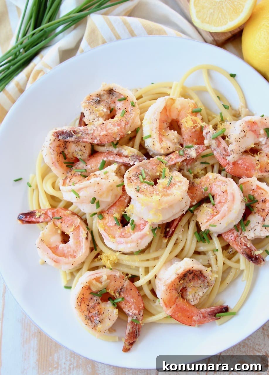 Lemon Garlic Butter Shrimp Scampi 3 Overhead shot of shrimp scampi over cooked pasta on white plate