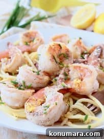 Lemon Garlic Butter Shrimp Scampi 5 Shrimp on top of pasta on plate with gold fork swirling pasta on the side of the plate