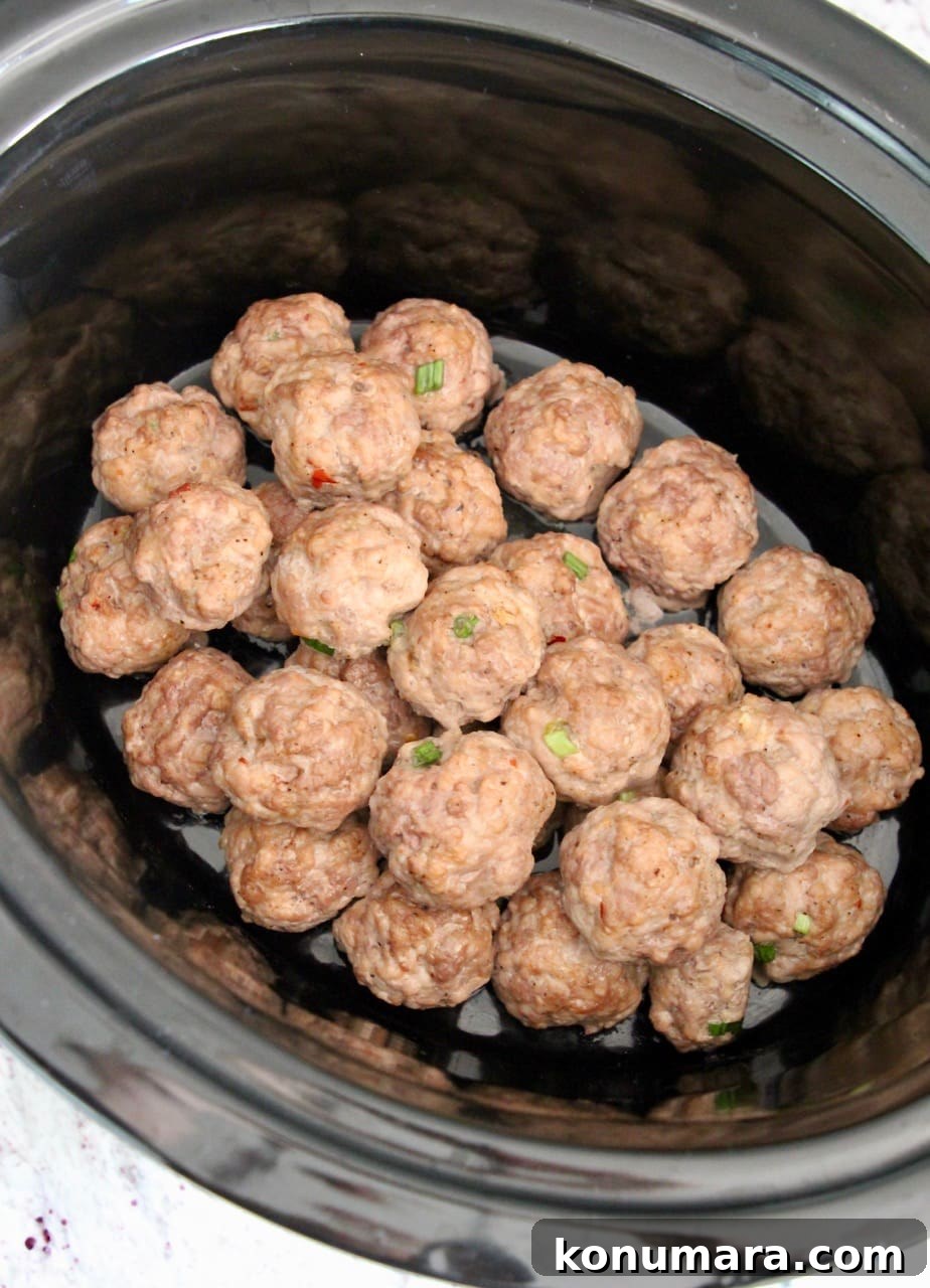 Slow Cooker Korean BBQ Meatballs with Gochujang Glaze 4 Korean meatballs piled on top of each other in a crock pot