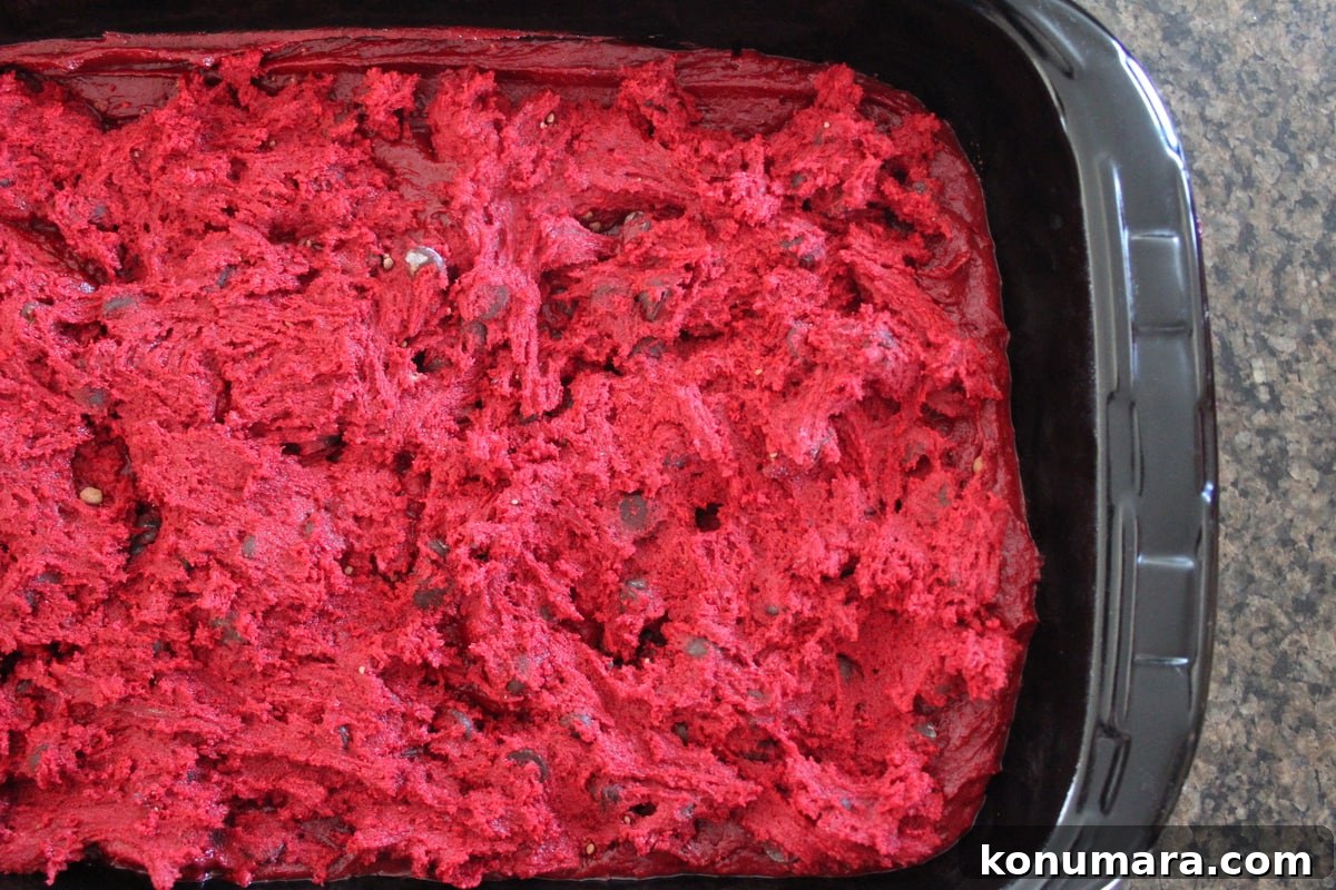 Brownie batter topped with red velvet cookie dough in a baking dish.